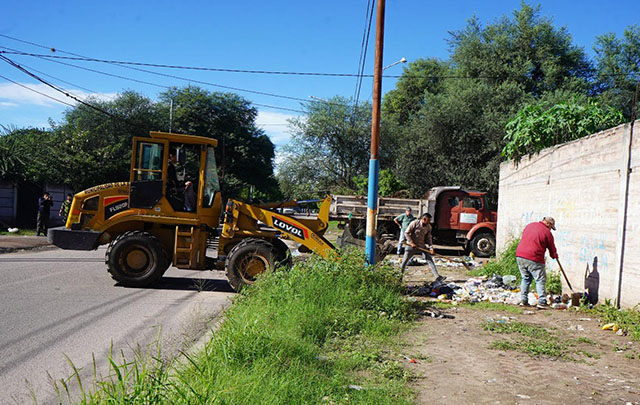 Operarios municipales realizando tareas de limpieza y desmalezamiento en una calle de Santiago del Estero