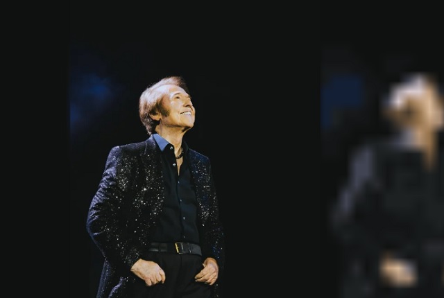 Raphael cantando en el escenario durante su tour Raphaelísimo en México