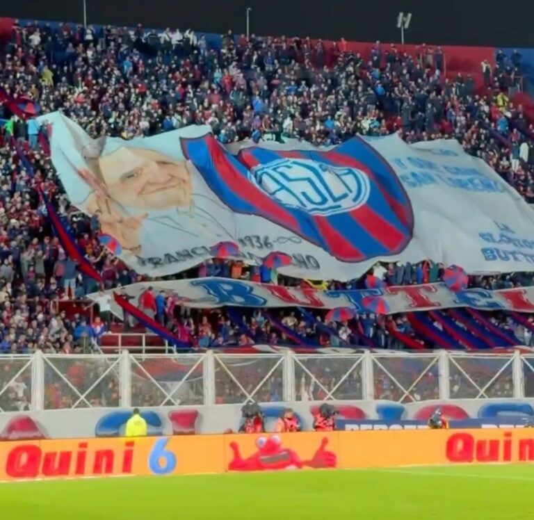 Hinchas de San Lorenzo despliegan banderas en tributo al Papa Francisco en el Nuevo Gasómetro.